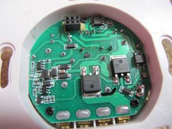 Close-up of a printed circuit board with electronic components inside a case, visible IC chips and connectors.
