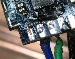Close-up of a Tuya CB2S module with a thin wire soldered to a QFN pad.