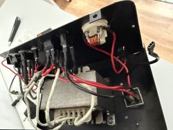 Wnętrze urządzenia elektronicznego z licznymi przewodami i komponentami.