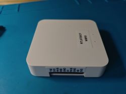 Electronic module with port and model labels on a white casing.