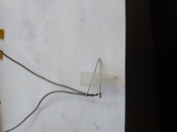 Wires attached to a transparent tube with thin metal rods on white paper