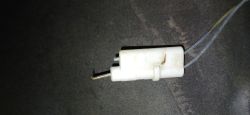Iskrownik piecyka gazowego z wygiętą elektrodą na tle ciemnej powierzchni