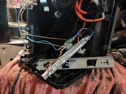 Photo of a disassembled device with a visible heating element and wires. It rests on a pink towel.