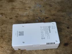 Sonoff THR320D Thermostat Case Sonoff THR320D thermostat case lying on a wooden surface.