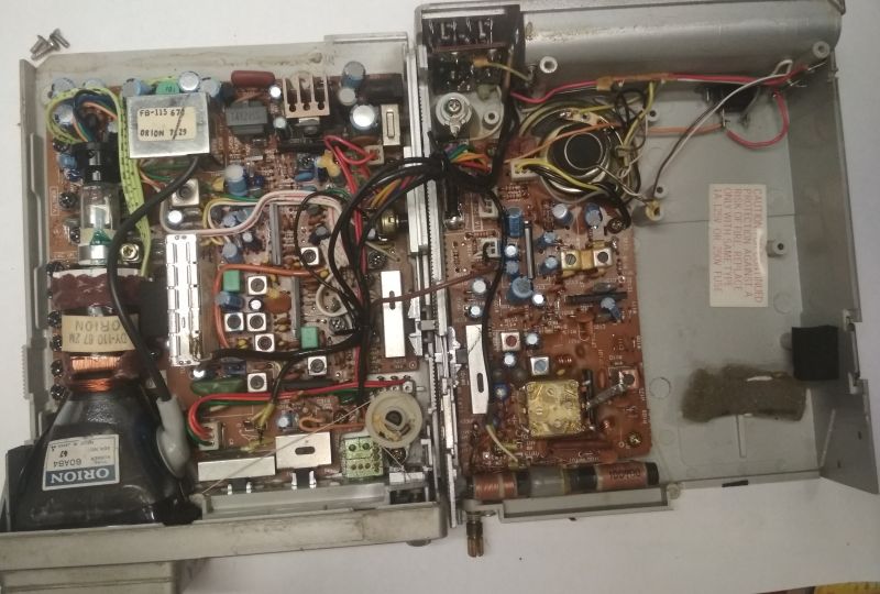 Wnętrze starego urządzenia elektronicznego pokazującego obie strony obudowy z widocznymi komponentami.