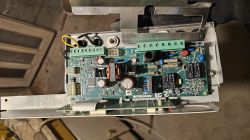 Płytka sterownika Intergas IC2 z widocznymi podzespołami elektronicznymi w metalowej obudowie.