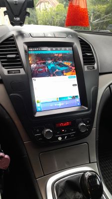Panel klimatyzacji i zamontowane chińskie radio w samochodzie Opel Insignia.