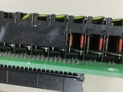 Close-up of a flip-dot display module showing copper-wound coils and a green PCB with pins