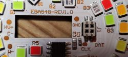Close-up of a printed circuit board with colored LEDs and connections labeled GND, DAT, CLK.