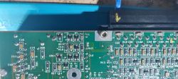 Zbliżenie na płytkę drukowaną z różnymi komponentami elektronicznymi.