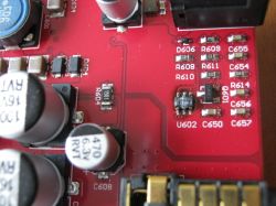 Układ scalony oznaczony jako 8205T IXMK4 w obudowie SOT-23-6 na czerwonym PCB