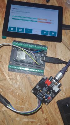 Touchscreen with VU meter bars and two ESP32 boards with wiring on a wooden work surface