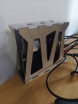 Homemade computer case with components mounted on a desk.