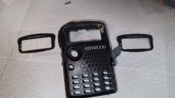 Obudowa radiotelefonu Kenwood z wyjętym okienkiem wyświetlacza i dwiema ramkami na ręczniku papierowym