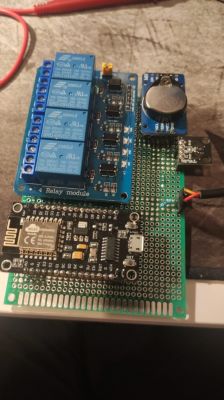 DIY Aquarium Controller with ESP8266 and Relay Module The photo shows a prototype board with an ESP8266 module, a 4-channel relay module, and additional sensors, placed on a table.