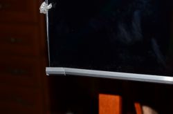 Uszkodzony róg telewizora Samsung z pękniętą obudową.