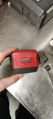 Czerwony akumulator Hilti B22 5.2 Li-Ion trzymany w dłoni.