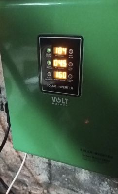 Zbliżenie na zielony inwerter solarny marki Volt Polska, wyświetlający napięcie, prąd i napięcie wyjściowe.