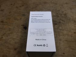 WiFi Socket Box Side with System Information The side of a WiFi socket box with system requirements, CE and RoHS marks, placed on a wooden table.