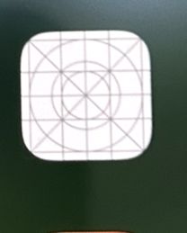 Biała ikona z szarymi liniami siatki na zielonym tle ekranu iPhone’a
