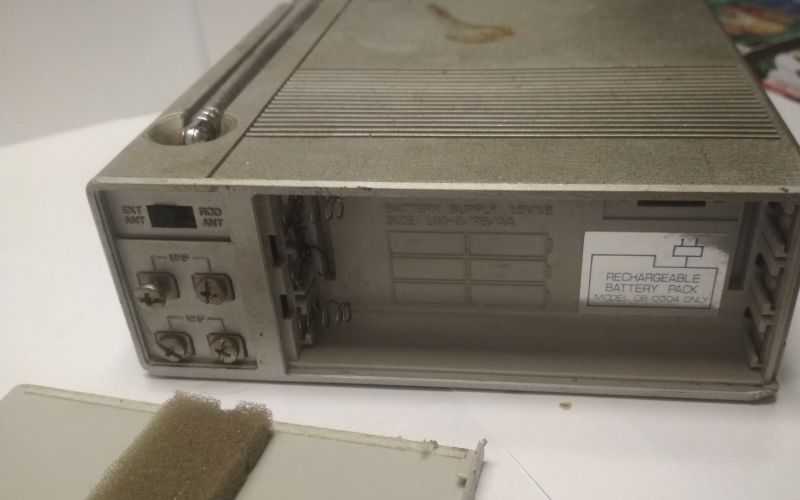 Widok zbliżony na otwartą komorę baterii mini telewizora Broksonic CIRT-2097T.