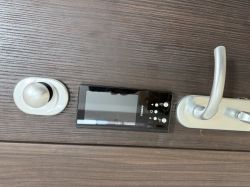 Electronic Door Lock with Control Panel Electronic door lock with a black control panel and handle on dark wooden doors.