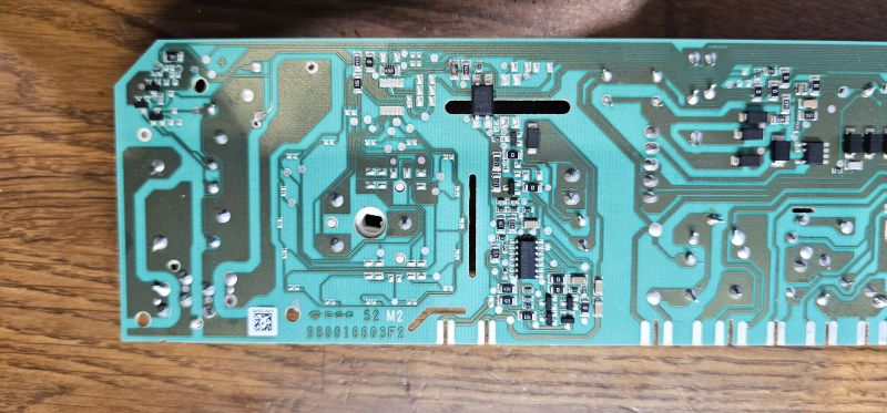 Zielono-niebieska płytka PCB z widocznymi ścieżkami, lutowaniami i elementami SMD