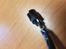 Zbliżenie na sześciostykową wtyczkę z czterema przewodami.