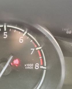 Obrotomierz w samochodzie z czerwoną migającą ikoną blokady.