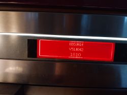 Czerwony wyświetlacz elektroniczny z numerami i literami na stalowej powierzchni