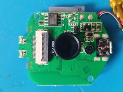 Printed circuit board with electronic components, micro USB socket, ribbon connector, and microphone.
