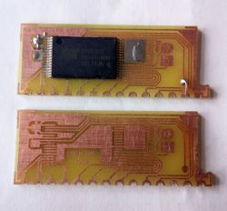 Two printed circuit boards, one with a mounted integrated circuit, the other circuit is empty.