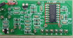Zdjęcie zielonej płytki drukowanej z zaznaczonym układem scalonym i czerwoną strzałką wskazującą na element.