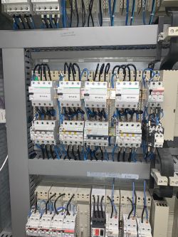 Widok wewnętrzny szafy elektrycznej z modułami zabezpieczeń i wyłącznikami różnicowymi