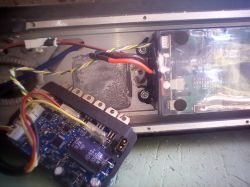 Otwarta obudowa hulajnogi elektrycznej z widocznymi przewodami i płytką elektroniki sterującej.
