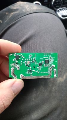 Close-up of a Sonoff circuit board held in hands.