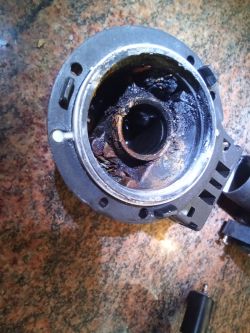 Zabrudzona i zużyta część mechaniczna z resztkami nagaru na blacie