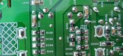 Zbliżenie na tylnią część płytki PCB z oznaczeniami elementów i ścieżkami.