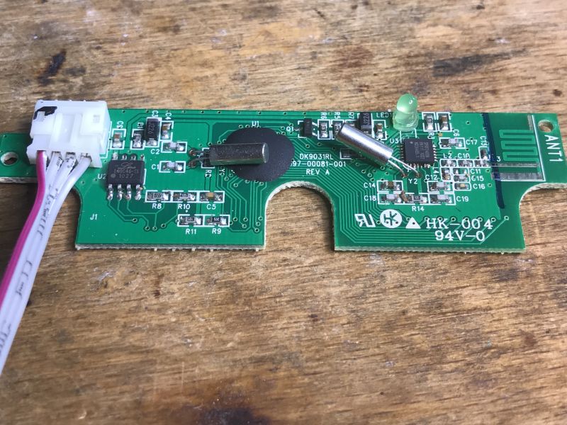 Zbliżenie na płytkę drukowaną klawiatury bezprzewodowej z widocznymi elementami elektronicznymi.