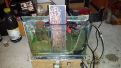 Printed Circuit Board Etching Process A printed circuit board is immersed vertically in an etching solution inside a glass etcher.