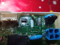 Zbliżenie na płytkę elektroniczną z widocznymi elementami takimi jak tranzystor, triak i oporniki.