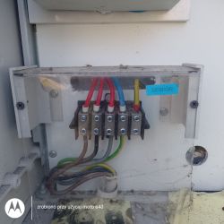 Złącze elektryczne z czterema przewodami fazowymi, niebieskim neutralnym i żółto-zielonym przewodem uziemiającym zmostkowanym z neutralnym.