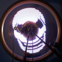 Bright white arcs form a circular pattern; mechanical parts and wires are visible at the center.