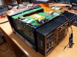 Otwarta obudowa elektronicznego urządzenia z widocznymi płytkami drukowanymi na biurku.