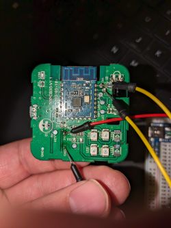 Circuit board held in hand with connected wires.