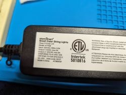 Label on the power adapter for Atomi Smart string lights with technical information.