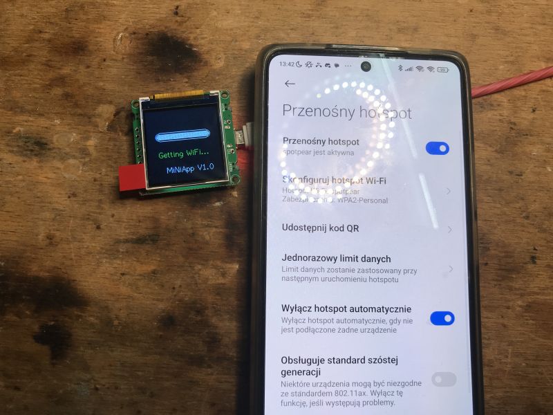 ESP32-C3 Module with Display and Phone as Hotspot ESP32-C3 module with a display next to a smartphone set as a WiFi hotspot.