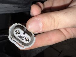 Zbliżenie na wtyczkę elektryczną lampy przeciwmgielnej trzymaną w dłoni