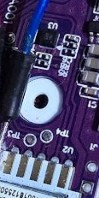Close-up of a circuit board with a purple base and electronic components.