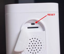 Close-up of a camera housing with a RESET button marked by a red arrow and label